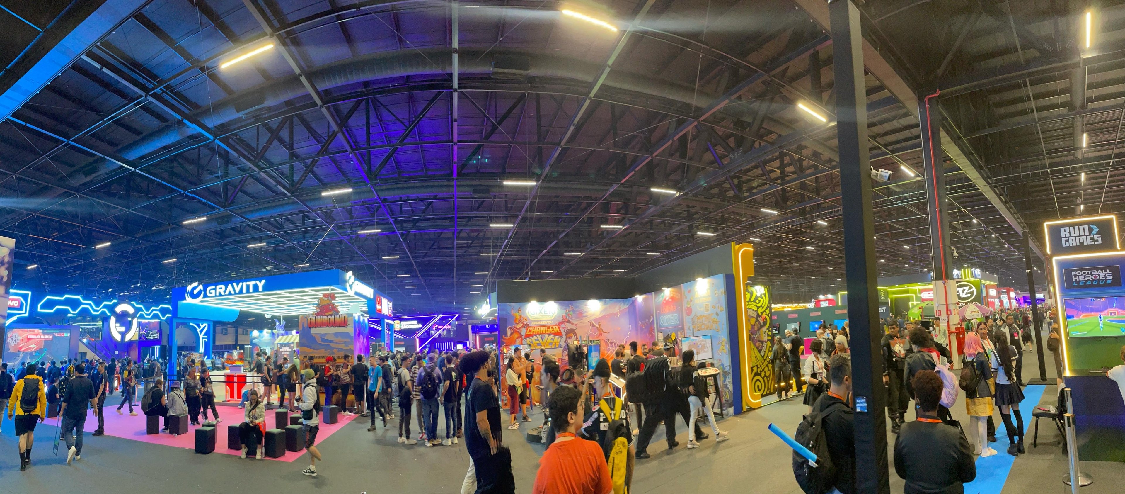 Foto panorâmica mostrando o evento GamesCom Latam 2025, com pessoas andando e diversos estandes a mostra